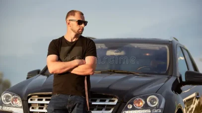 homme-d-affaires-et-sa-voiture-noire-portrait-une-position-sûre-elle-même-réussie-devant-avec-les-mains-croisées-à-long-terme-167880015