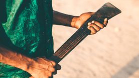 Young african man holding machete.